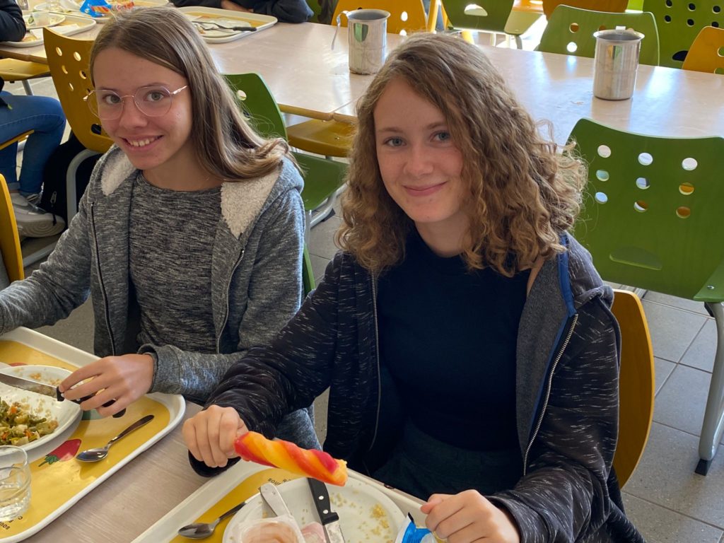 Deux lycéennes posent à table en fin de repas, un sorbet à la main